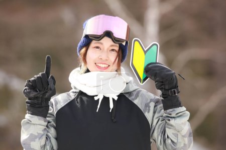 Une femme en tenue de snowboard avec une marque de débutant