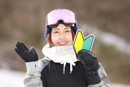 A woman in snowboarding wear with a beginner mark
