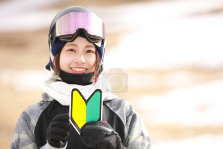 Photo for A woman in snowboarding wear with a beginner mark - Royalty Free Image
