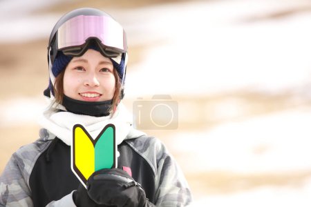 Eine Frau in Snowboardbekleidung mit Anfängermarke