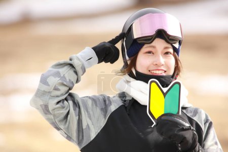 Photo for A woman in snowboarding wear with a beginner mark - Royalty Free Image