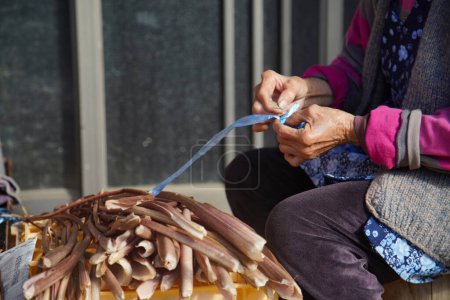Téléchargez les photos : Une femme séchant des coquilles de pommes de terre - en image libre de droit