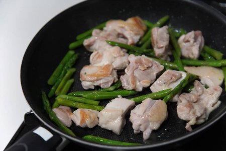 Preparing stir-fried chicken and asparagus
