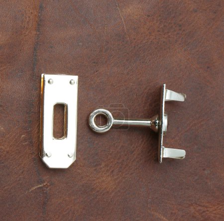 Metall-Accessoires für Taschen isoliert auf Lederhintergrund