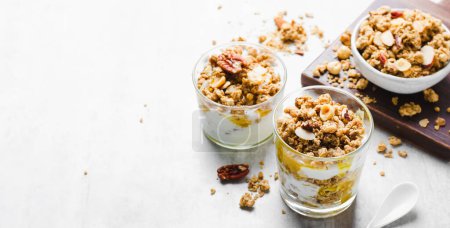 Photo for Granola and Yogurt Parfaits, Healthy Breakfast or Snack, Muesli with Nut Mix and Honey on Bright Background - Royalty Free Image