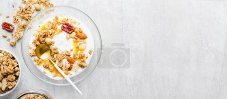 Photo for Granola with Nut Mix and Yogurt in a Boal, Healthy Breakfast, Muesli with Dried Berries on Bright Background - Royalty Free Image