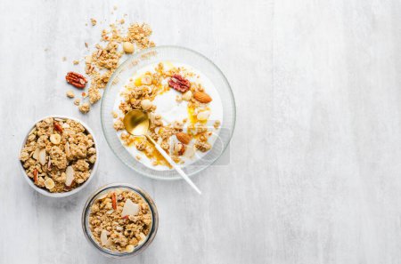 Photo for Granola with Nut Mix and Yogurt in a Boal, Healthy Breakfast, Muesli with Dried Berries on Bright Background - Royalty Free Image