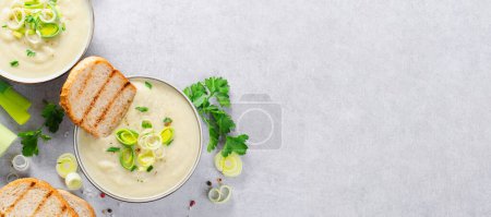 Lauchsuppe, Komfortmahlzeit, Kartoffel-Lauch-Rahmsuppe, vegetarische Kost auf hellgrauem Hintergrund