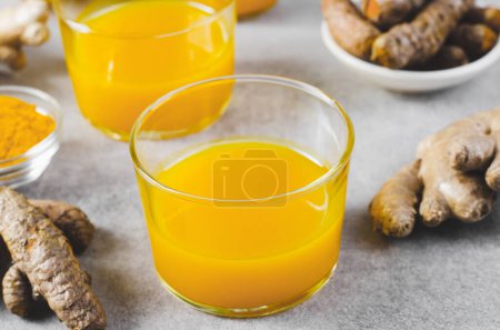 Turmeric Shots, Healthy Beverage with Turmeric and Spices, Jamu Juice, Immunity Booster Drink on Bright Grey Background
