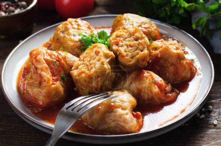 Foto de Homemade Cabbage rolls with meat, rice and vegetables. Stuffed cabbage leaves also known as sarma, golubtsy, dolma on Dark Rustic Background - Imagen libre de derechos