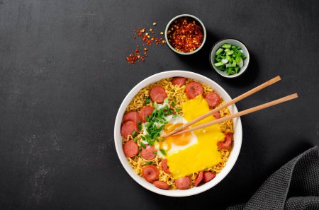 Téléchargez les photos : Nouilles Ramen aux saucisses, aux œufs, au fromage fondu et à l'échallion, Ramyeon Shin au micro-ondes ou Ramyun, nouilles coréennes sur fond sombre - en image libre de droit