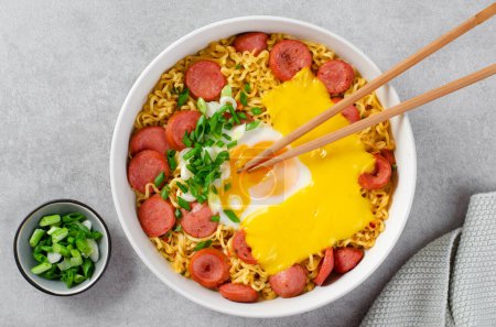 Photo for Ramen Noodles with Sausages, Egg, Melted Cheese and Scallion, Microwave Shin Ramyeon or Ramyun,Korean Noodles on Bright Background - Royalty Free Image