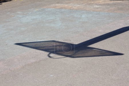 Téléchargez les photos : L'ombre d'un panneau arrière de basket sur un terrain de sport de cour - en image libre de droit