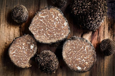 Photo for Truffle mushrooms have a dark, knobby exterior and a soft, fragrant interior. They grow symbiotically with the roots of certain trees, such as oak and hazelnut, and are typically harvested using specially trained dogs or pigs - Royalty Free Image