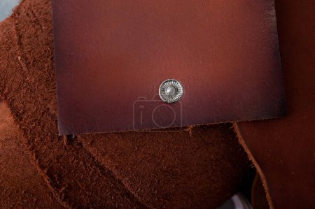 Téléchargez les photos : Portefeuille en cuir véritable repose sur la table, accessoires pour hommes, éléments pour la fabrication de produits en cuir véritable, petite entreprise artisanale - en image libre de droit