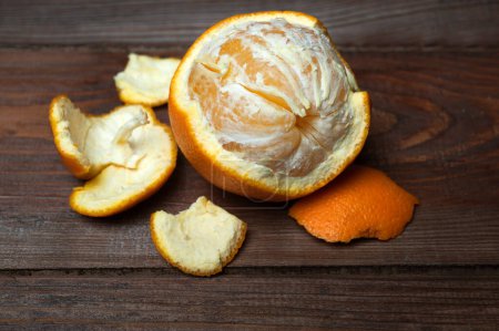 Photo for Close-up texture of an peeled ripe sweet tangerine fruit on a wooden board. - Royalty Free Image