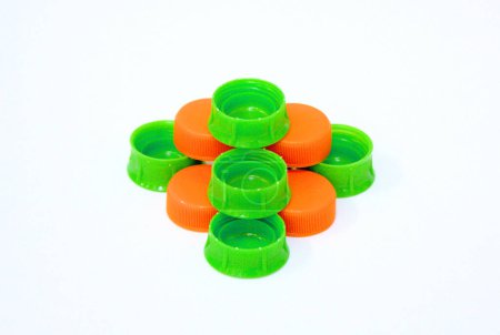 Green and orange color plastic bottle caps isolated on white background.