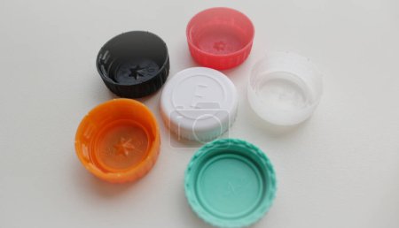 Six color plastic bottle caps on grey background