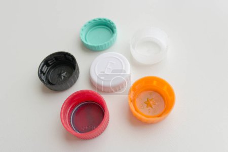 Bunch of six color plastic bottle lids on grey background