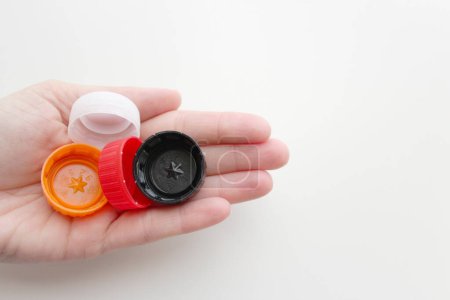 Photo for Human hand holding plastic bottle caps on the left - Royalty Free Image