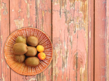 Téléchargez les photos : Kiwi et abricots sur fond bois - en image libre de droit