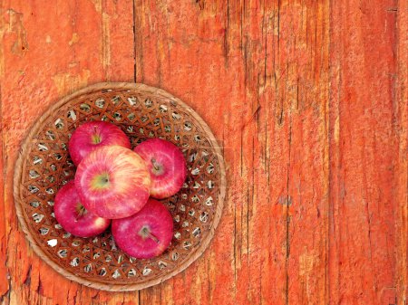 Téléchargez les photos : Vue du dessus des pommes fraîches mûres dans le panier en osier sur fond en bois - en image libre de droit