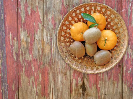 Téléchargez les photos : Kiwi et oranges sur le fond en bois - en image libre de droit