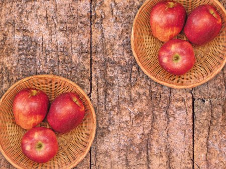 Téléchargez les photos : Vue du dessus des pommes fraîches mûres dans des paniers en osier sur fond en bois - en image libre de droit