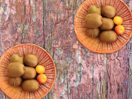 Photo for Kiwi and apricots on the wooden background - Royalty Free Image