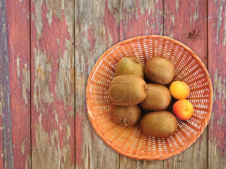 Photo for Kiwi and apricots on the wooden background - Royalty Free Image