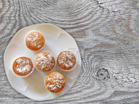 Téléchargez les photos : Cupcakes en poudre de sucre sur le fond en bois - en image libre de droit