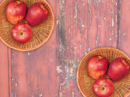 Foto de Vista superior de manzanas maduras frescas en cestas de mimbre sobre fondo de madera - Imagen libre de derechos