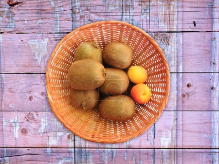 Téléchargez les photos : Kiwi et abricots sur fond bois - en image libre de droit