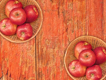 Téléchargez les photos : Vue du dessus des pommes fraîches mûres dans des paniers en osier sur fond en bois - en image libre de droit