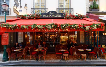 Téléchargez les photos : PARIS, France - 19 décembre 2023 : Des gens assis dans un café traditionnel français Montorgueil décoré pour Noël 2023. Il est situé rue Montorgueil dans le 1er arrondissement de Paris - en image libre de droit
