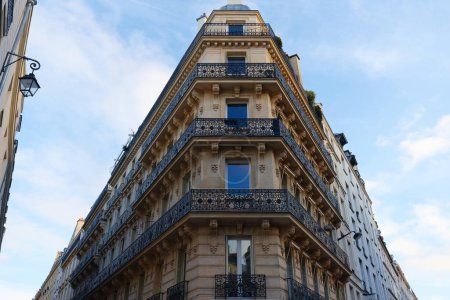 Die Fassade eines traditionellen französischen Hauses mit typischen Balkonen und Fenstern. Paris, Frankreich.