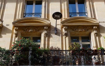 La façade de la maison française traditionnelle avec des balcons et des fenêtres typiques. Paris, France.