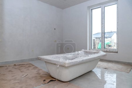 Téléchargez les photos : Bathtub on the construction site ready for installation. High quality photo - en image libre de droit
