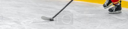 Téléchargez les photos : Joueur de hockey avec une rondelle sur un bâton de hockey dans un match sur glace. bannière avec espace de copie. Photo de haute qualité - en image libre de droit