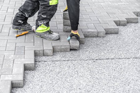 Téléchargez les photos : Pose de pavés emboîtés lors de la construction de trottoirs et de routes. - en image libre de droit