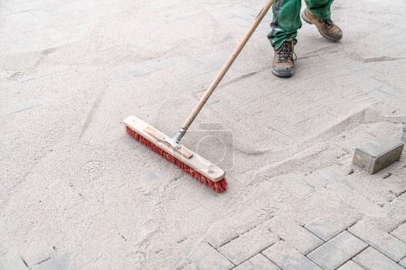 Photo for Filling the gaps in the new pavement with sand. - Royalty Free Image