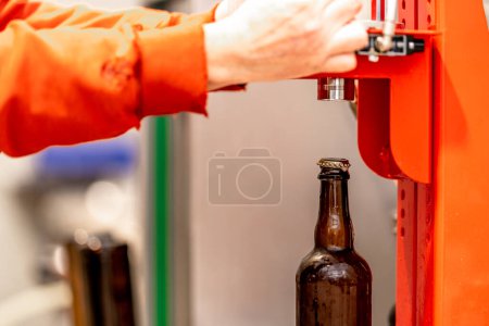 Foto de Tapado mecánico de botellas de cerveza en la cervecería. Foto de alta calidad - Imagen libre de derechos