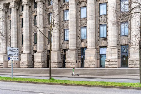 Foto de Colonia, Alemania - 23 de marzo de 2023: edificio administrativo histórico con un scooter eléctrico moderno en frente de la entrada - Imagen libre de derechos