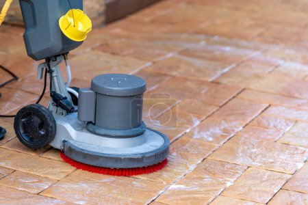 limpieza manual de pavimentos de hormigón y piedra con un cepillo mecánico. Foto de alta calidad