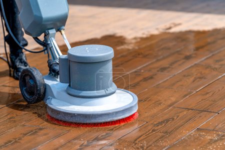 limpieza manual de pavimentos de hormigón y piedra con un cepillo mecánico. Foto de alta calidad
