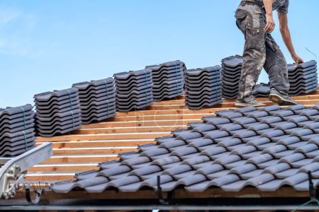 Téléchargez les photos : Artisan pose de carreaux de céramique cuite sur le toit. - en image libre de droit