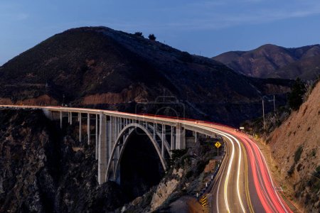Autolichtwege beleuchten die Bixby Creek Bridge. Big Sur, Kalifornien, USA.
