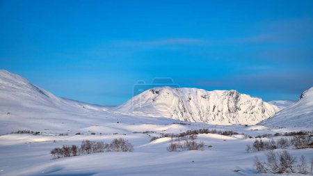 Hautes montagnes norvégiennes dans la neige. Montagnes couvertes de neige. Paysage enneigé en Scandinavie