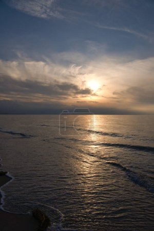 Coucher de soleil, mer illuminée. Plage de sable au premier plan. Des ondes lumineuses. Mer Baltique. Paysage sur la côte