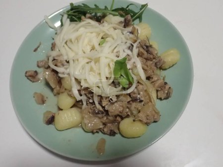 portion of gnochi with mushroom sauce and cheese 